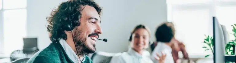 A man wearing a headset engaged in an effective outbound prospecting strategy.