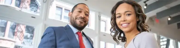 Two sales team members smile after a successful sales meeting