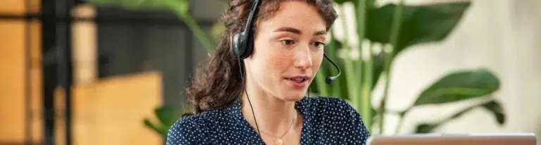 Female cold caller at desk with laptop.