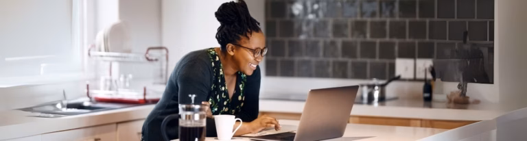 Woman smiling at a laptop, hiring SEO content writers.