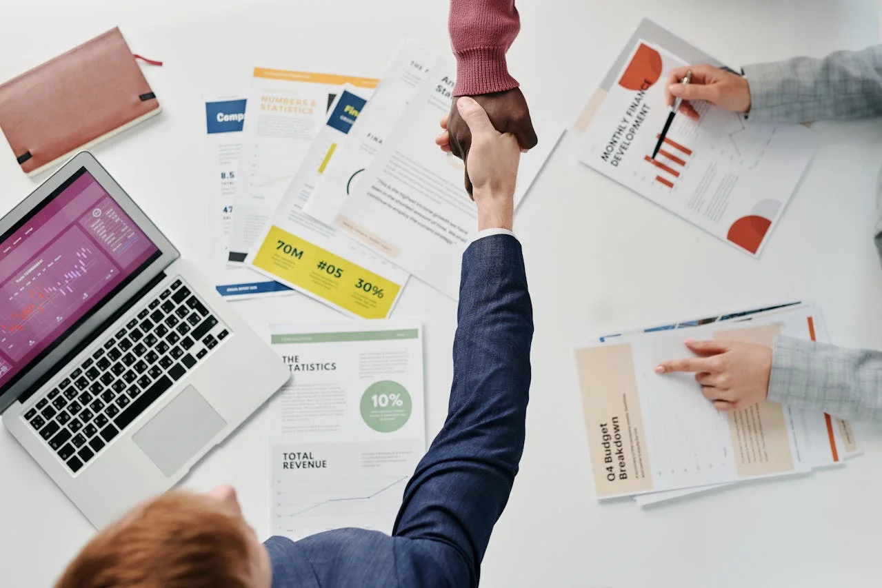 A well-aligned sales team shakes hands and congratulates each other on growth