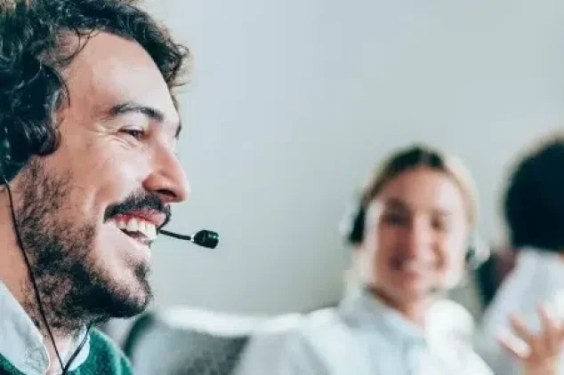 A man wearing a headset engaged in an effective outbound prospecting strategy.