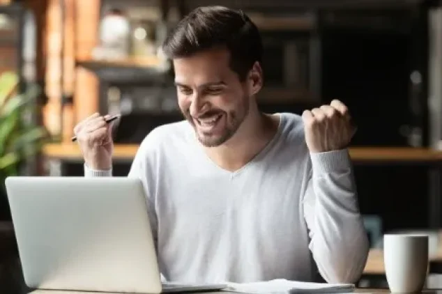 Excited person using a laptop for list builder success.