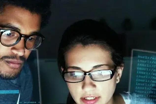 Three individuals engrossed in IT Lead Generation Services, attentively examining a computer screen.