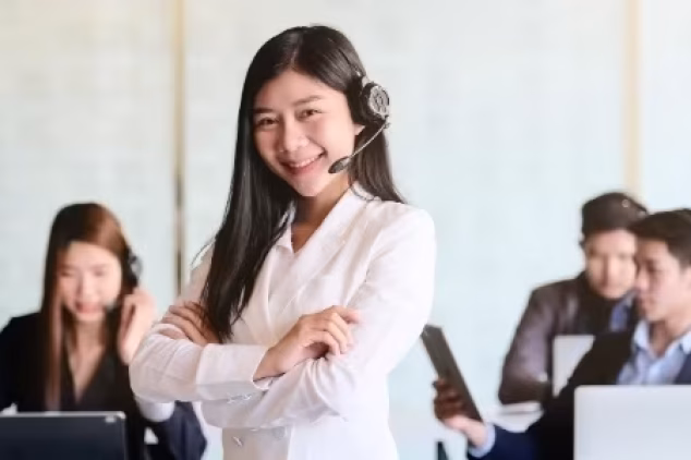 Professional cold caller smiling at desk to boost business growth.