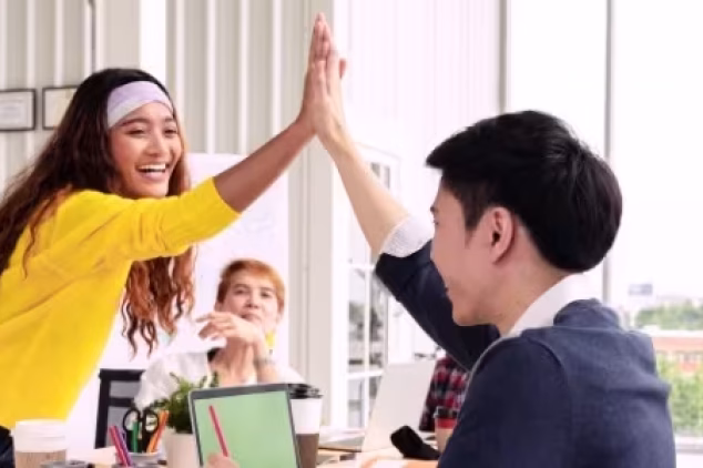 Team from an SEO agency for startups high-fiving for success.
