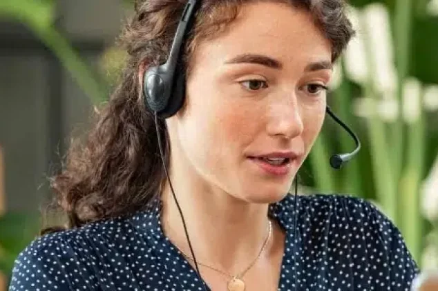 Female cold caller at desk with laptop.