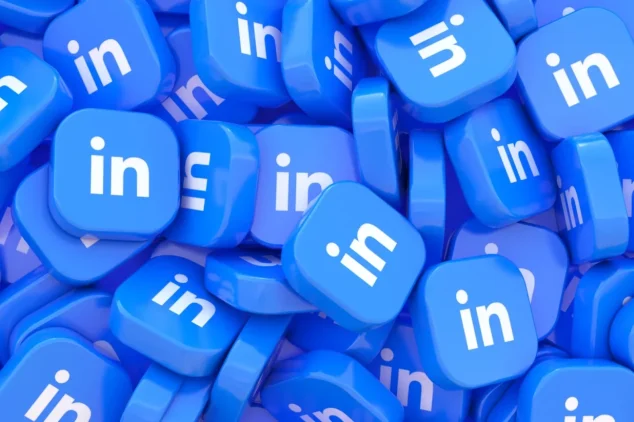 A graphic image featuring a large pile of blue LinkedIn logo buttons